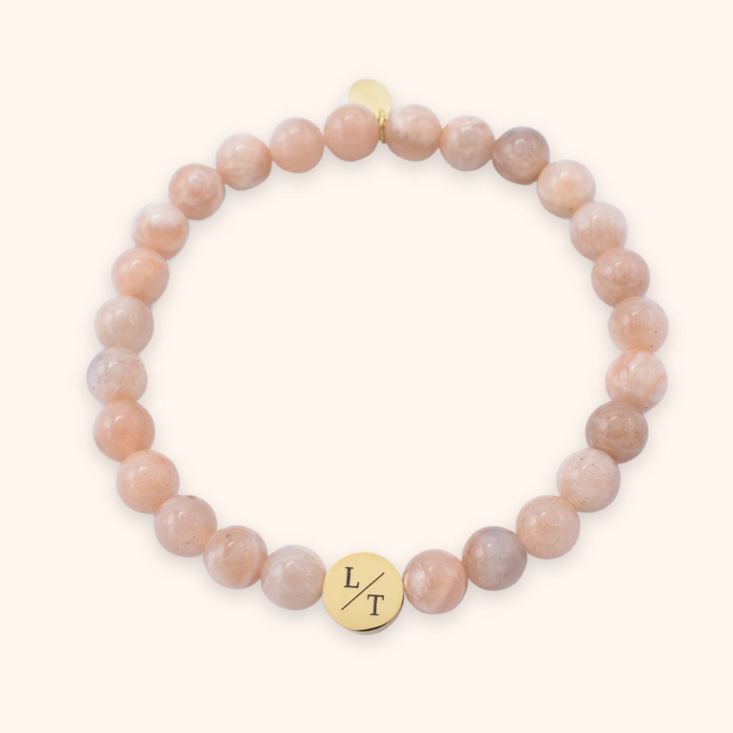 Kralenarmband voor vrouwen met maansteen en zonnesteen kralen van 6 mm groot. Gegraveerd met meerdere letters op een goud stainless steel kraaltje.