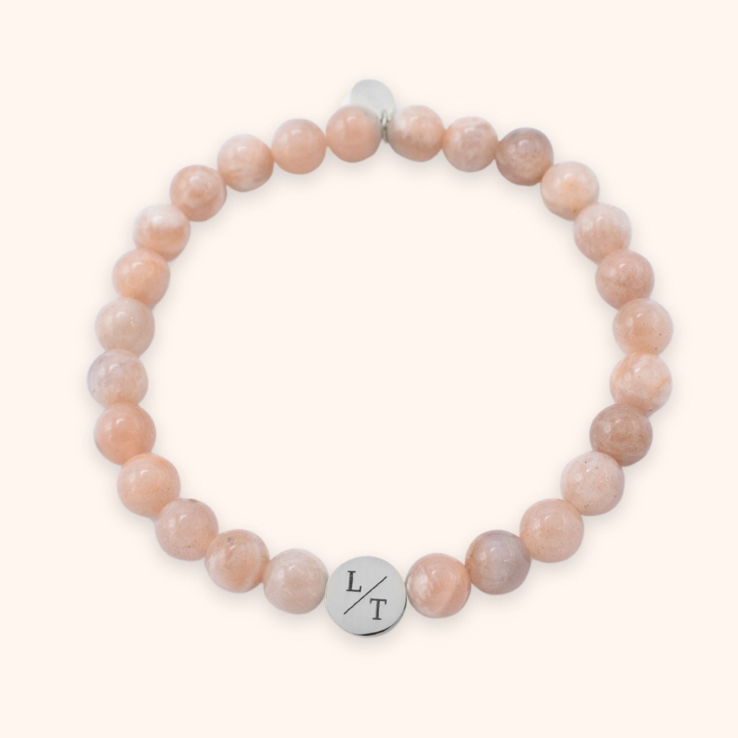 Kralenarmband voor vrouwen met maansteen en zonnesteen kralen van 6 mm groot. Gegraveerd met meerdere letters op een zilver stainless steel kraaltje.