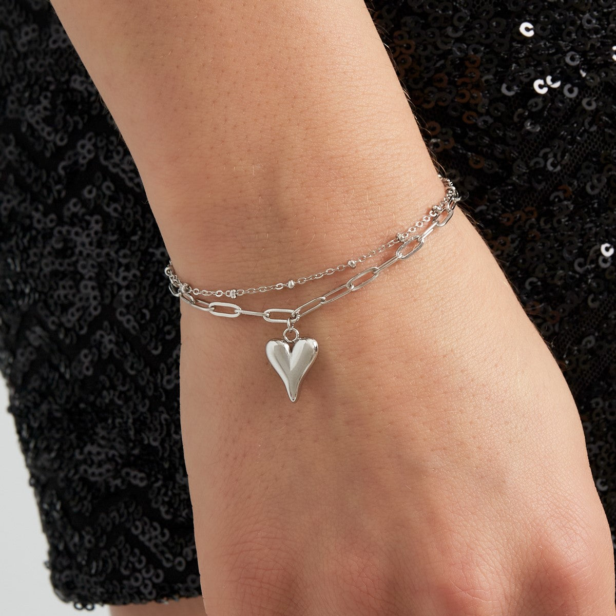 Zilverkleurige dubbele schakelarmband voor dames met hart bedel gemaakt van stainless steel.